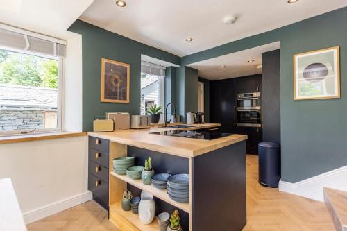 a kitchen with green walls and a counter with plates at Langdale Boulders, Ambleside, Fantastic views in Chapel Stile