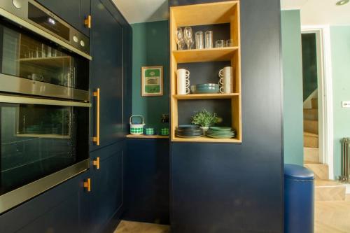 a kitchen with blue cabinets and a blue wall at Langdale Boulders, Ambleside, Fantastic views in Chapel Stile