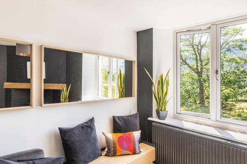 a living room with two windows and a couch at Langdale Boulders, Ambleside, Fantastic views in Chapel Stile
