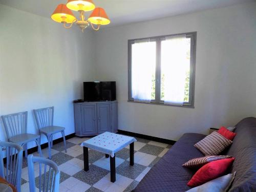 un salon avec un canapé, une table et une fenêtre dans l'établissement Ronce-les-Bains - MAISON MITOYENNE avec son JARDIN PRIVATIF - AU CALME et SOUS LES PINS, à Ronce-les-Bains