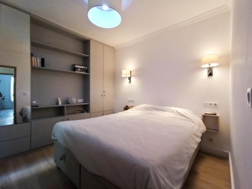 a bedroom with a white bed and a mirror at Home Rental Service in Paris