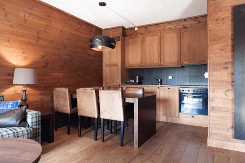 a kitchen with wooden cabinets and a table and chairs at Vestlia Resort in Geilo