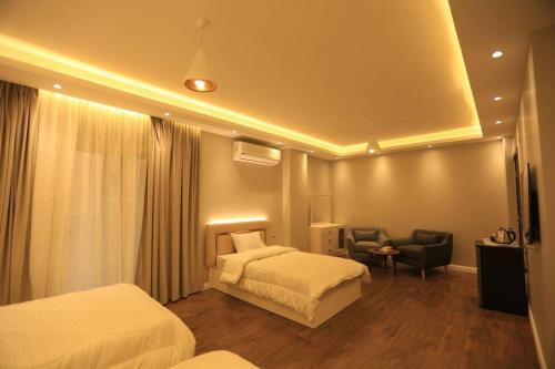 a hotel room with two beds and a chair at Munir`s residence 2 in Cairo