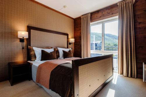 a bedroom with a large bed and a large window at Vestlia Resort in Geilo