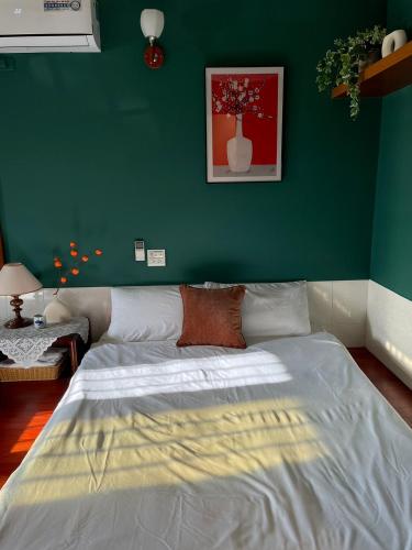 a bedroom with a large bed with a green wall at 嘉義行滿旅宿&包棟親子寵物烤肉平價好趣宿 in Zhuqi