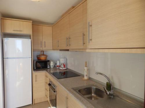 a kitchen with a sink and a white refrigerator at MH38 - Apartment with wonderful sea views in Murcia