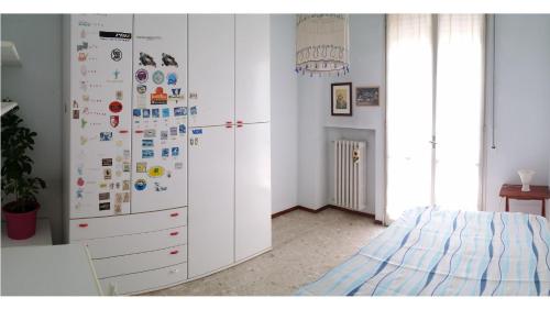 ペーザロにあるMaria's Apartmentのベッドルーム1室(白い冷蔵庫、磁石付)
