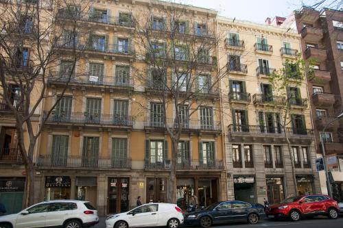 een groot gebouw met auto's geparkeerd voor het bij Tendency Apartments 6 in Barcelona