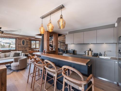 - une cuisine avec un bar avec des chaises et un canapé dans l'établissement Appartement 4 chambres avec sauna, hammam et salle de sport, à proximité du Mont d'Arbois - FR-1-569-186, à Megève