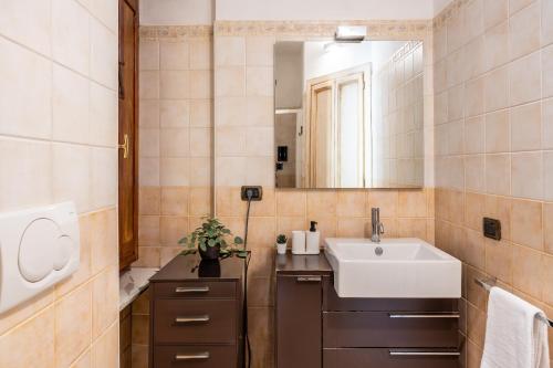 een badkamer met een wastafel en een spiegel bij [TICINESE-DUOMO ELEGANTE] Centrale con A/C in Milaan