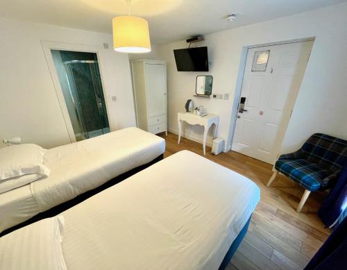 a hotel room with two beds and a chair at The Queen's Head Hotel in Buxton