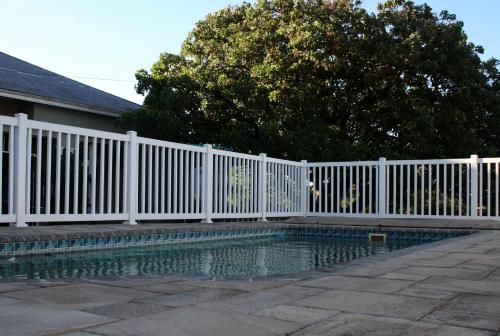 a white fence next to a swimming pool at 1920s Charm on Waveren in Tulbagh