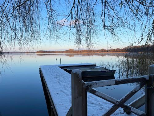 a boat on a dock on a lake in the snow at Urlaub am Plätlinsee Haus Rike in Wustrow