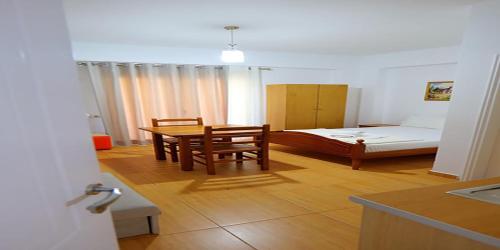 a room with a bed and a table and chairs at Alex & Sofi Hotel in Himare