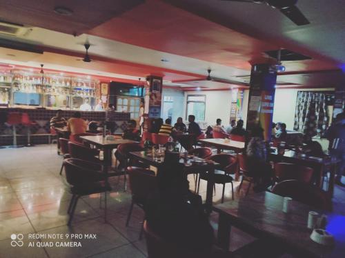 un ristorante con persone sedute ai tavoli in una stanza di HOTEL ANAND a Jhansi