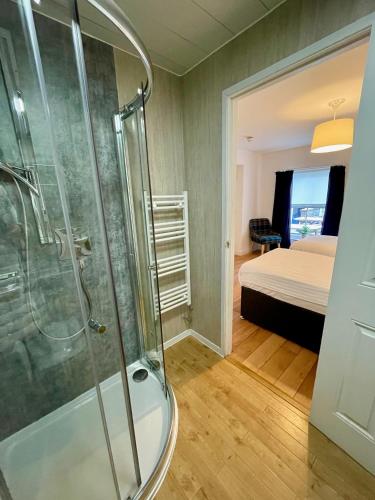 a bathroom with a shower and a bedroom at The Queen's Head Hotel in Buxton