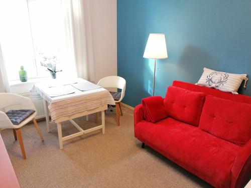 ein Wohnzimmer mit einem roten Sofa und einem Tisch in der Unterkunft Isensee - ABC322 in Wismar