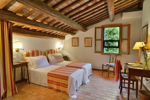 1 dormitorio con cama, mesa y ventana en Frassanelle en Rovolon