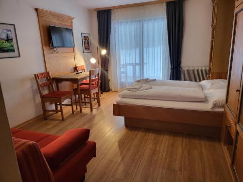 um quarto de hotel com uma cama, uma mesa e cadeiras em Gasthof Ramona em Scharnitz