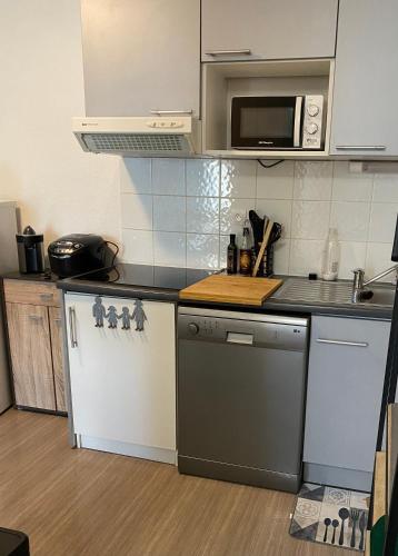 eine Küche mit einem Kühlschrank und einer Mikrowelle in der Unterkunft Niort Home in Niort