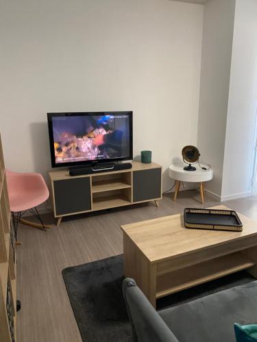 ein Wohnzimmer mit einem Flachbild-TV auf einem Schrank in der Unterkunft Niort Home in Niort