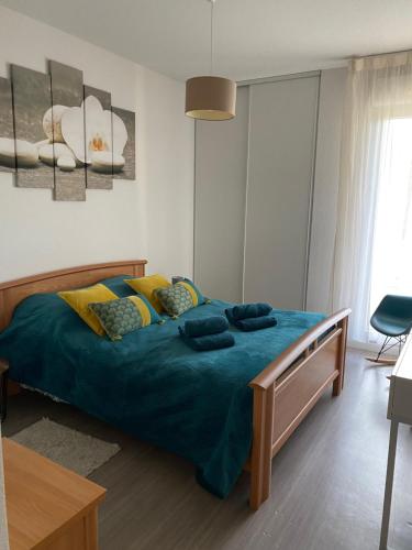 Schlafzimmer mit einem Bett mit blauer Decke in der Unterkunft Niort Home in Niort