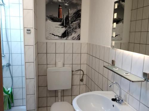 y baño con aseo blanco y lavamanos. en Landgasthof "Hotel zum Norden", en Jagel