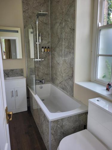 La salle de bains est pourvue d'une baignoire, d'une douche et de toilettes. dans l'établissement The Morritt Hotel, à Barnard Castle