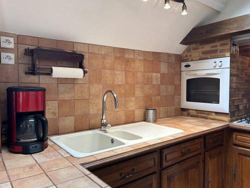 cocina con fregadero y microondas en 520 - Appartement T3 en duplex en plein cœur d'Erquy, en Erquy