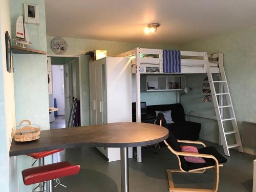um pequeno quarto com uma mesa e um beliche em 523 - A ERQUY, proximité centre ville et plage du centre, dans un immeuble tranquille em Erquy