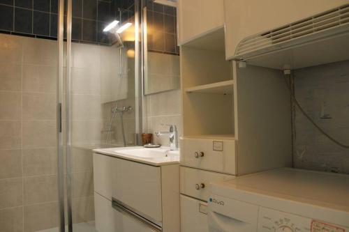 uma casa de banho branca com um chuveiro e um lavatório. em 523 - A ERQUY, proximité centre ville et plage du centre, dans un immeuble tranquille em Erquy