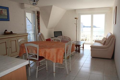une cuisine et un salon avec une table et des chaises dans l'établissement 521 - Bel appartement avec balcon vue mer à Erquy en bordure de la plage du centre et à 300m des commerces, à Erquy