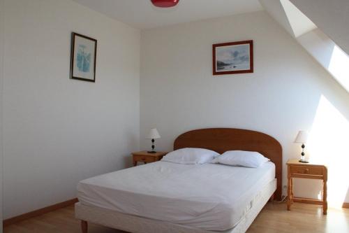 um quarto com uma cama branca e duas mesas de cabeceira em 521 - Bel appartement avec balcon vue mer à Erquy en bordure de la plage du centre et à 300m des commerces em Erquy