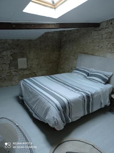 un lit dans une chambre avec un mur de briques dans l'établissement Moliere, à Molières-Cavaillac