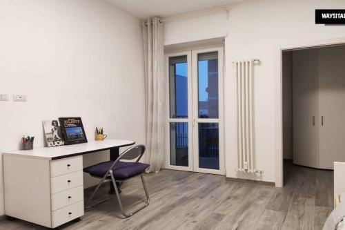 Schlafzimmer mit einem Schreibtisch, einem Stuhl und einem Fenster in der Unterkunft De Angeli District in Mailand