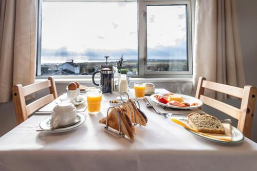 een tafel met ontbijtproducten en een raam bij Summerfield Lodge B&B in Youghal