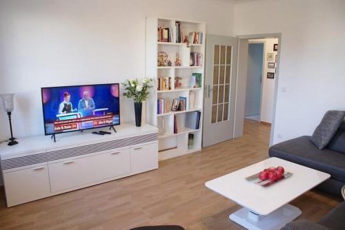 un soggiorno con TV a schermo piatto su un centro di intrattenimento bianco di Lübsche Burg - ABC248 a Wismar