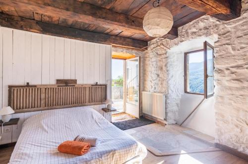 a bedroom with a bed in a stone wall at La Ferme De Chalas in Valgorge