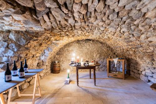 a wine tasting room with a stone wall at La Ferme De Chalas in Valgorge