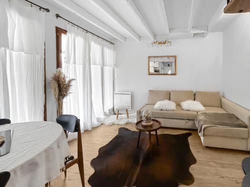 Sala de estar blanca con sofá y mesa en Refuge Montagnard - Terrasse et Local à Ski ou Vélo, en Ax-les-Thermes