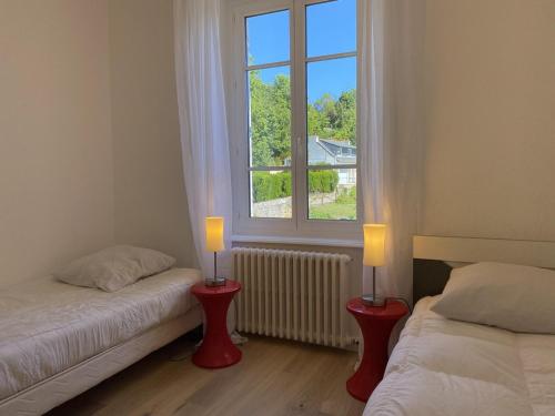 1 Schlafzimmer mit 2 Betten und 2 Kerzen vor einem Fenster in der Unterkunft 536 - Maison familiale en bordure de la plage du centre d'Erquy in Erquy