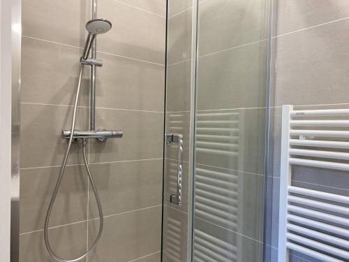 une douche avec une porte vitrée dans une salle de bain dans l'établissement 536 - Maison familiale en bordure de la plage du centre d'Erquy, à Erquy