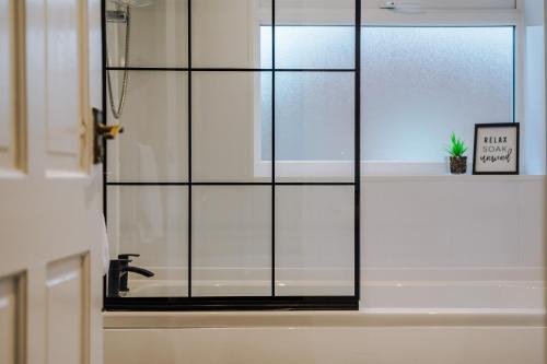 een badkamer met een glazen raam en een wastafel bij Elm-G House in Manchester