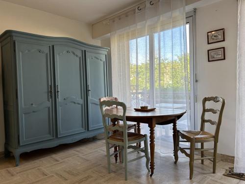 une salle à manger avec une table et des chaises et une grande fenêtre dans l'établissement 541 - Studio en rez-de-jardin à quelques pas de la plage, à Erquy