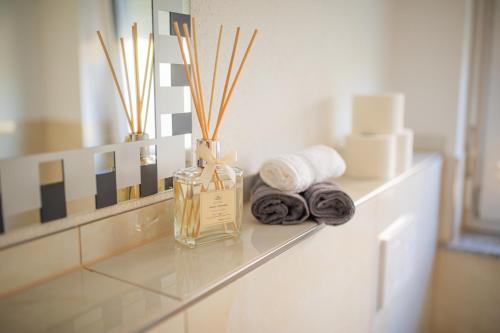 a bathroom counter with towels and a bottle of perfume at Auszeit in Radolfzell in Radolfzell am Bodensee