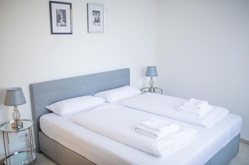 a white bed with two white pillows and two lamps at Auszeit in Radolfzell in Radolfzell am Bodensee