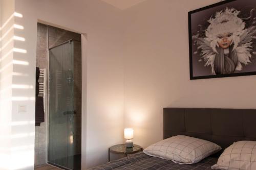 - une chambre avec un lit et une douche en verre dans l'établissement la chambre de l'ange, à Saint-Herblain