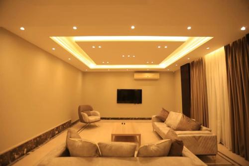 a living room with two couches and a tv at Munir`s residence 2 in Cairo