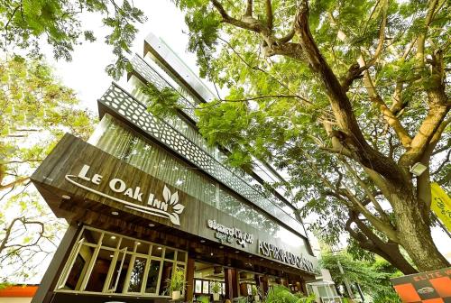 un edificio con un letrero que lee el Oak inn en Le Oak Inn, en Mysore