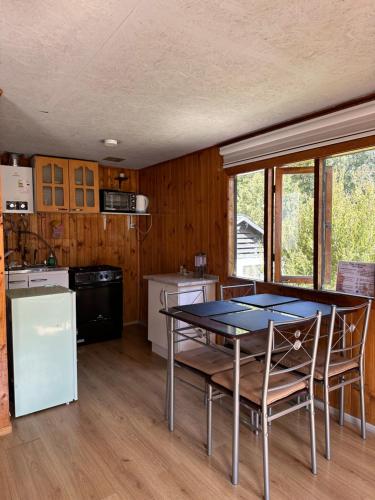 a kitchen with a table and chairs in a room at Cabañas Kuyén Austral in Hornopiren